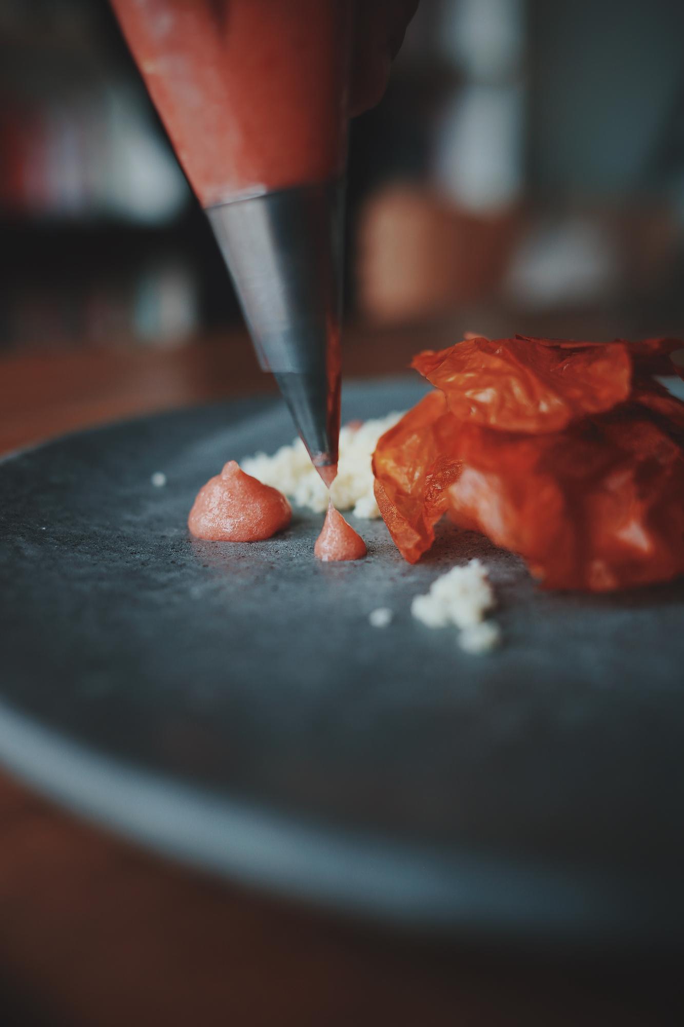 Chef using precision tool for sauce